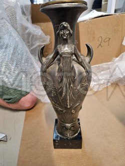 Ваза с девушкой серого цвета на черной подставке.